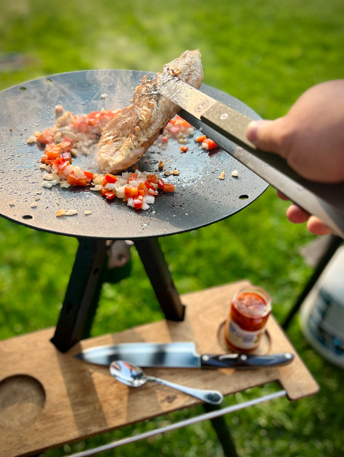 a titanium tong being used to cook chicken