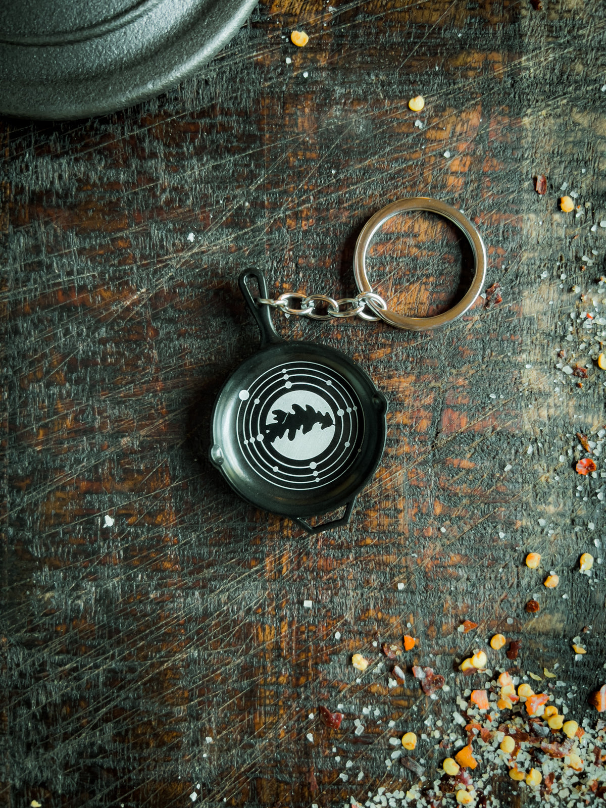 a keychain shaped like a small skillet with the Dryadcookery logo engraved